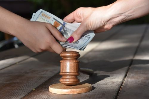 hands exchanging money over a gavel - reasons to change child support concept
