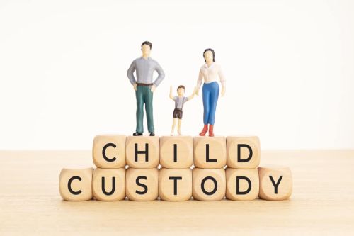 Child custody concept. Wooden blocks with text and woman, man and child figurine - modify custody order
